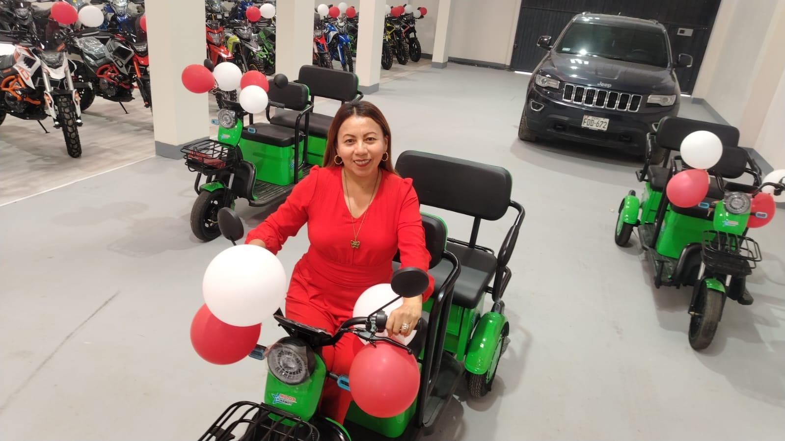 Representante de JHERAN junto a trimotos en exhibicion